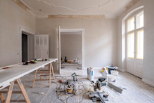 Een woning die verbouwd wordt. Er staan materialen en gereedschappen in de kamer.