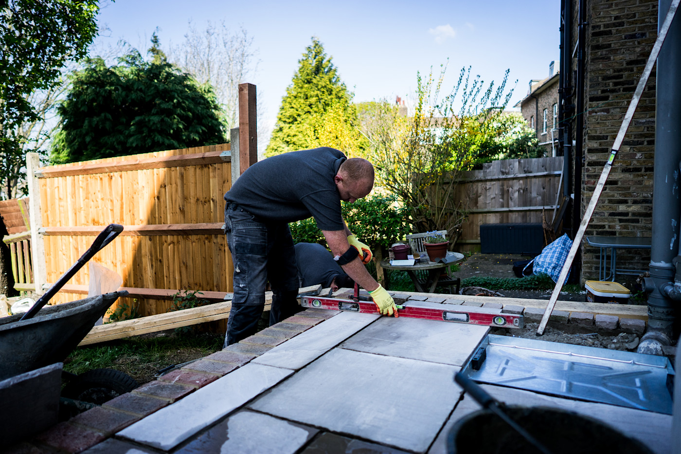 Een stratenmaker die tegels legt in de tuin