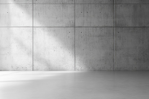 Minimalistisch modern interieur met een betonnen muur en vloer, strak en industrieel design.