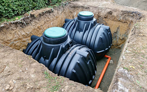 vakman verricht werkzaamheden aan septic tank