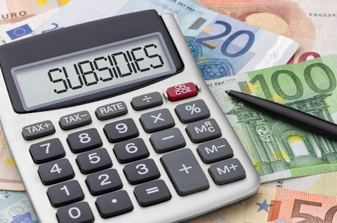 Rekenmachine, geld en pen op bureau voor subsidies berekenen