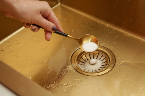 Keukengootsteen wordt gereinigd met baking soda als natuurlijk schoonmaakmiddel.