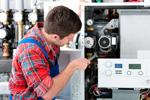 airconditioning specialist werkt aan de reparatie van de buitenunit van een airco.