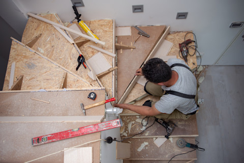 Vakman werkt aan een houten trap naar de zolder van een woning