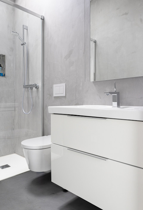 Moderne badkamer met microcement op de muur, vrijstaand bad dubbele wastafel en grote spiegel