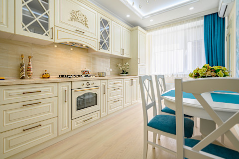 Close-up van een klassieke keuken met beige, wit en cyaan tinten en elegante afwerking.
