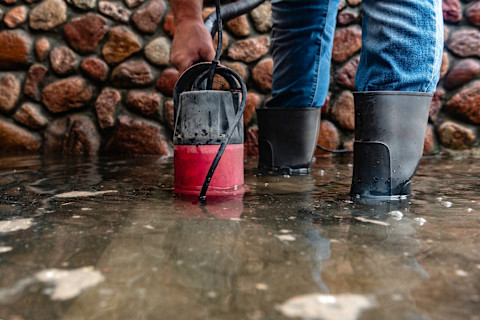 Iemand is bezig met water weg te pompen met een dompelpomp