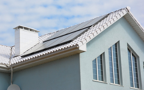 Wit dak van een woning met energiezuinig design en zonlichtreflectie.