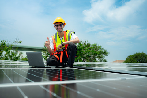 Technicus inspecteert een zonne-installatie en voert tests uit.