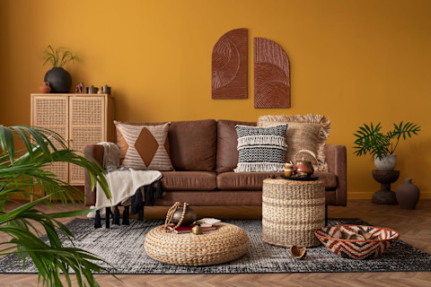 Een ruime woonkamer met oranje bankstel met een oranje met blauw tapijt