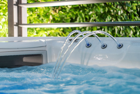  Close-up van een jacuzzi met fontein en skimmer, detail van watercirculatie en onderhoud.
