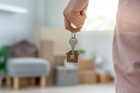 Vrouw houdt de sleutels van haar nieuwe woning vast tijdens de verhuizing.