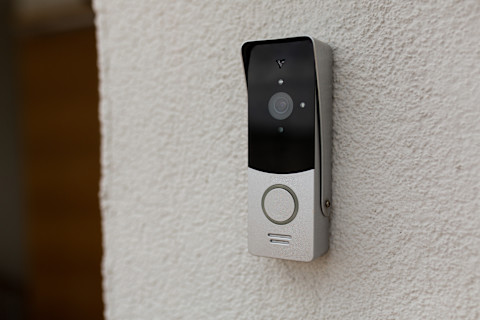 Moderne deurbel bevestigd aan de muur van het huis voor veiligheid en het gemak bij de voordeur