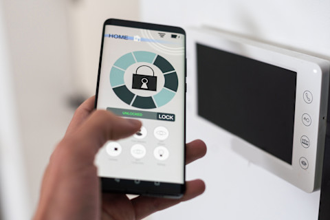 Smartphone met een beveiligingsapp die een alarmsysteem beheert.