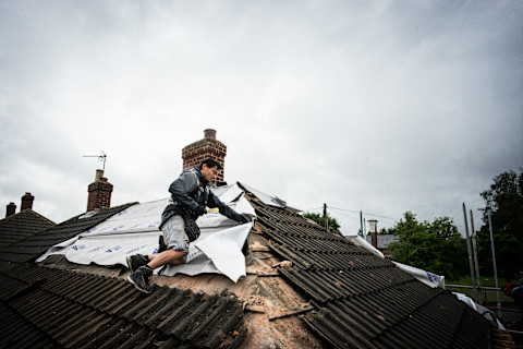 dakdekker werkt aan een dak om ruimte te maken voor een dakterras