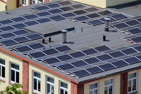 Zonnepanelen op een plat dak van een gebouw, netjes geordend voor optimale zonopbrengst.