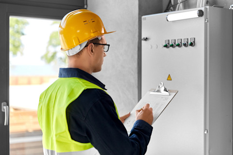 Een elektricien maakt aantekeningen om een offerte voor het project voor te bereiden