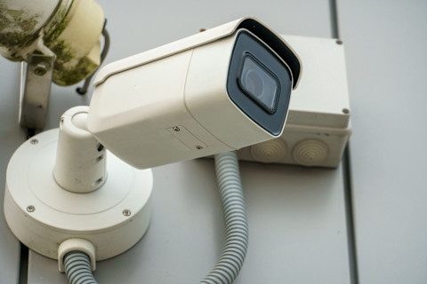 Close-up van een beveiligingscamera met scherp beeld gericht op een woning.