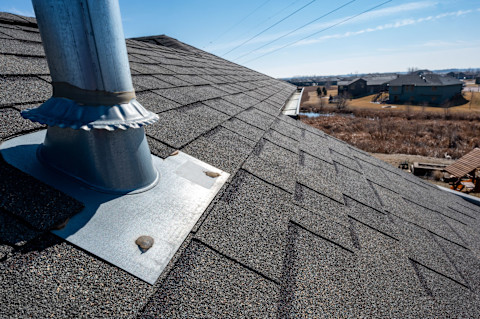 Dakdoorvoer met ventilatieopening op een schuin dak, afgedicht met siliconenkit.  