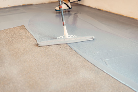 Vloerspecialist is bezig met het vakkundig aanbrengen van een beton kleur gietvloer
