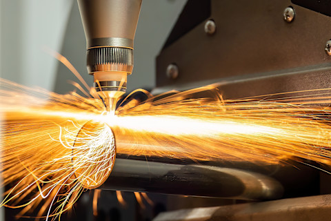 Een close up van een vezel laser snijmachine voor staal en metalen snijden met oranje vonken