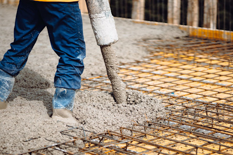 Een bouwplaats waar beton wordt gestort voor funderingen en betonnen constructies