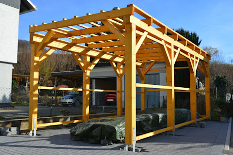 Houten raamwerk van een carport die gebouwd wordt 