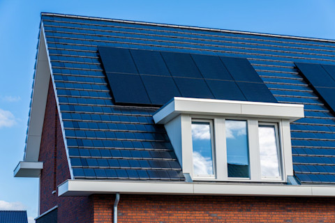 Moderne woning met een strakke kunststof dakkapel en grote ramen.