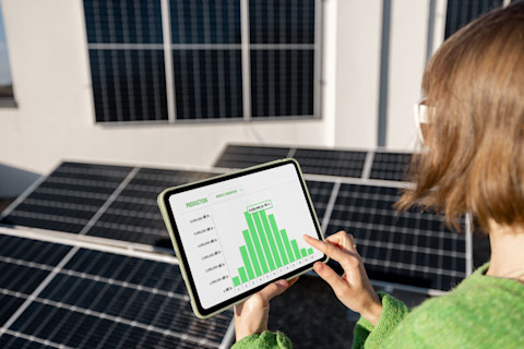Vrouw controleert zonnepanelen verbruik op tablet