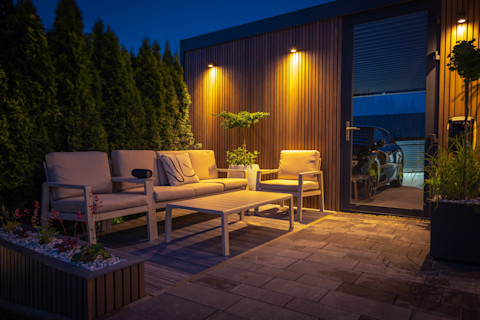 Een sfeervolle tuin met warme verlichting en loungeset