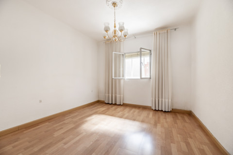 Lege kamer met fris gestucte witte muren en een licht houten vloer, klaar voor verdere inrichting.