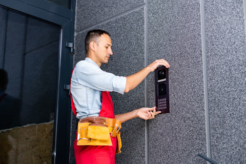 Installateur is bezig met een intercom installatie in de hal van een gebouw