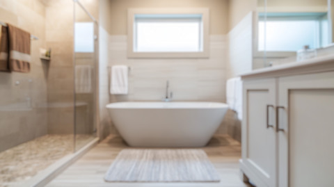 Een wit bad in een badkamer met douche aan de linkerkant
