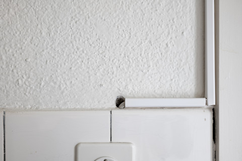 Witte kunststof kabelgoten en afdekplaten voor het netjes wegwerken van elektrische bedrading.
