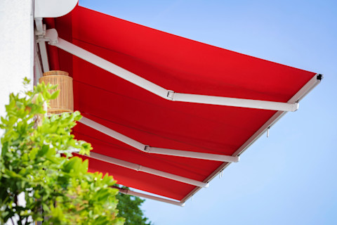 Waterdichte zonnescherm in een felrode kleur die optimaal beschermt tegen de invloeden van de zon en regen