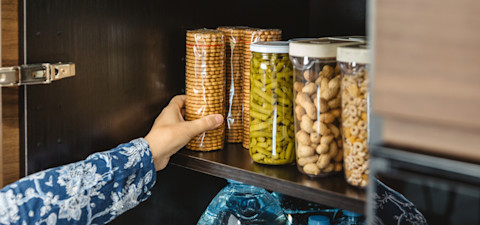 Lichte bijkeuken met wasmachine, mandje en groen accent voor een frisse, minimalistische sfeer.