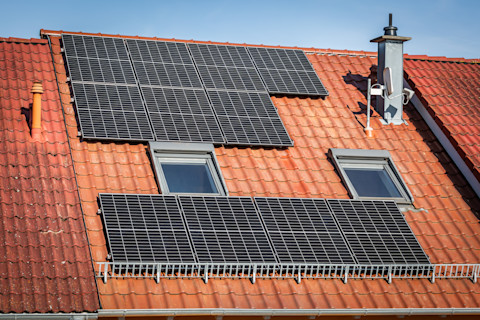 Zonnepanelen op het dak van een gezinswoning, duidelijk zichtbaar als duurzame energiebron.