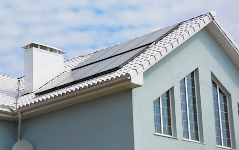 Wit dak van een woning met energiezuinig design en zonlichtreflectie.
