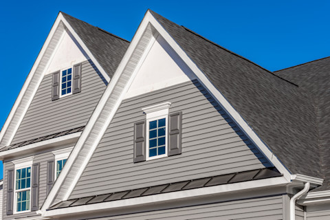 Grote woning met twee puntdaken, moderne uitstraling en duurzame dakbedekking.
