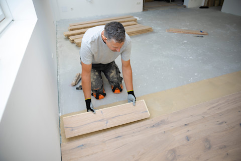 Vakman legt nieuwe laminaatvloer in een lege woning