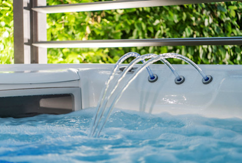Close-up van een jacuzzi met fontein en skimmer, detail van watercirculatie en onderhoud.