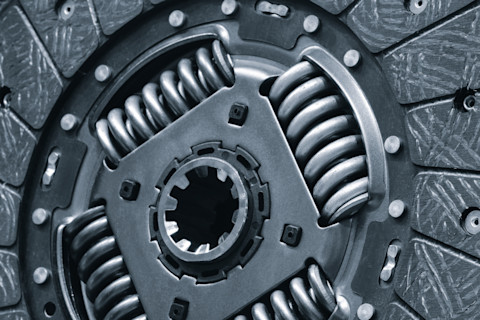 Koppelingsplaat en drukgroep van een auto liggen klaar voor vervanging tijdens een reparatie. 