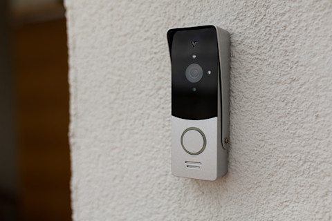 Moderne deurbel bevestigd aan de muur van het huis voor veiligheid en het gemak bij de voordeur
