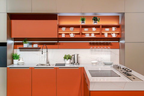 Moderne oranje keuken met strakke oranje keukenkastjes en ingebouwde apparatuur in een eigentijds interieur.