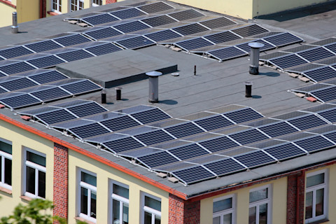 Zonnepanelen op een plat dak van een gebouw, netjes geordend voor optimale zonopbrengst.