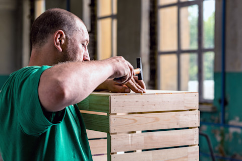 vakman timmert aan een houten ombouw