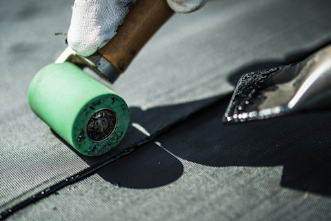 Close-up van EPDM rubberen dakbedekking tijdens de installatie door een dakspecialist