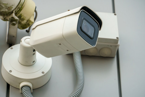 Close-up van een beveiligingscamera met scherp beeld gericht op een woning.