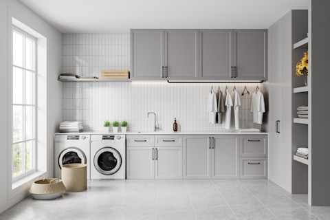 Modern grijze bijkeuken met wasmachine en stijlvolle opbergruimte voor een strakke uitstraling.