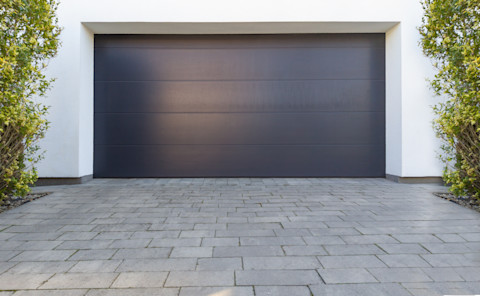 Een grijze garagedeur in een moderne witte woning